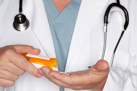 Male Doctor Abstract Pouring Out Pills from a Prescription Bottleの写真素材
