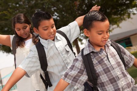 Cute Brothers and Sister with Backpacks Having Fun Walking to School.の写真素材