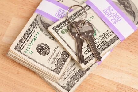 House Keys on Stack of Money - Cash for Keys Program.の写真素材