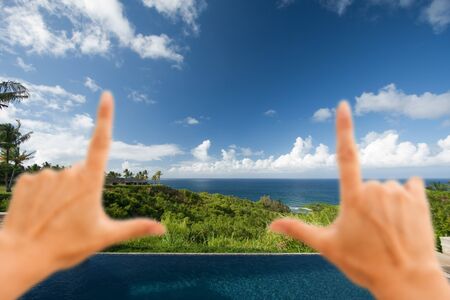 Hands Framing Breathtaking Hawaiian Ocean View Deck and Pool with Deep Blue Skyの写真素材