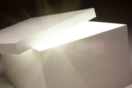 White Box with Lid Revealing Something Very Bright on a Grey Background.の写真素材