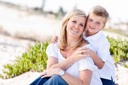 Cute Son Hugs His Attractive Mom Portrait at The Beach.の写真素材