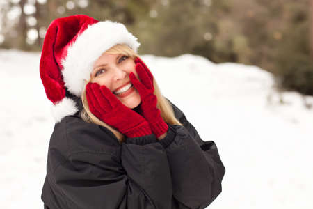 Attractive Santa Hat Wearing Blond Woman Having Fun in The Snow on a Winter Day.の写真素材