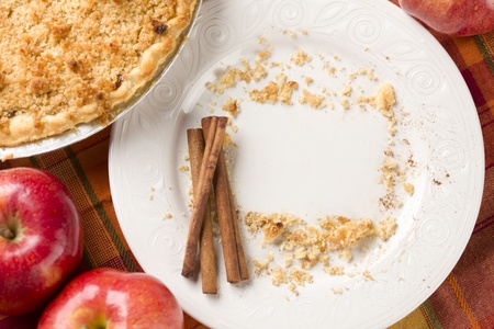 Overhead Abstract of Apples, Cinnamon Sticks, Pie and Empty Plate with Remaining Crumbs Cleared Into Rectangular Copy Room Space and Fork - Ready for Your Own Message.の写真素材