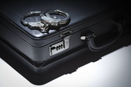 Pair of Handcuffs and Briefcase Under Spot Light Abstract.の写真素材