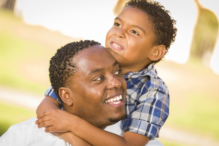 Happy African American Father and Mixed Race Son Playing Piggyback in the Park.の写真素材
