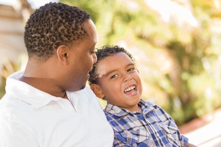 Happy African American Father and Mixed Race Son Talking in the Park.の写真素材