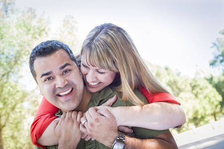 Happy Attractive Mixed Race Couple Piggyback at the Park.の写真素材