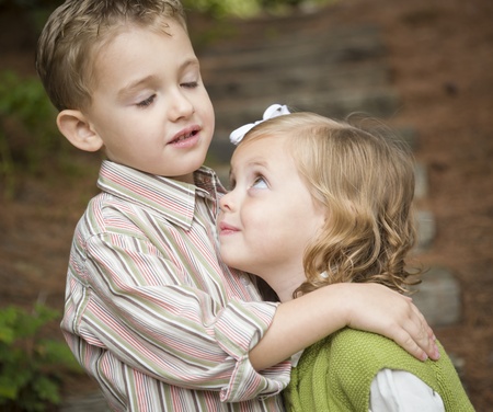Adorable Brother and Sister Children Hugging Each Other Outside.の写真素材