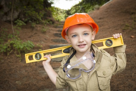 Happy Adorable Child Boy with Level, Hard Hat and Goggles Playing Handyman Outside.の写真素材