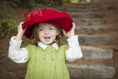 Happy Adorable Child Girl with Red Hat Playing Outside.の写真素材