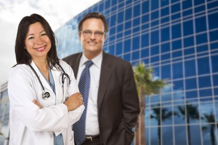 Attractive Hispanic Doctor or Nurse and Businessman in Front of Corporate Building.の写真素材