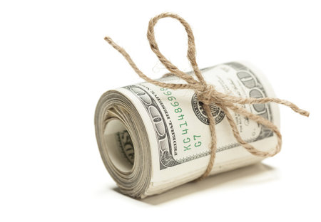 Roll of One Hundred Dollar Bills Tied in Burlap String Isolated on a White Background.の写真素材