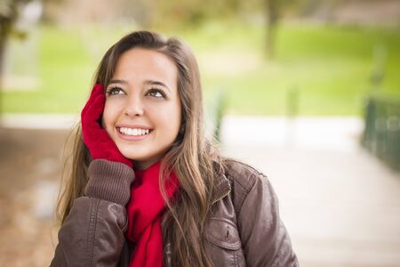Pretty Festive Smiling Woman Portrait Wearing a Red Scarf and Mittens Outside.の写真素材