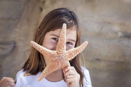 Young Pretty Girl Playing with Starfish.の写真素材