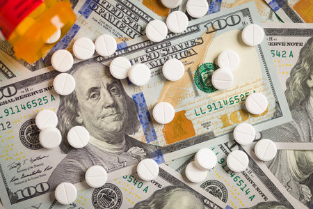 Medicine Pills Scattered on Newly Designed U.S. One Hundred Dollar Bills.