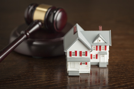Gavel and Small Model House on Wooden Table.の写真素材