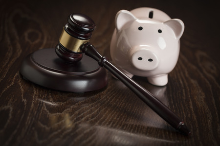 Gavel and Piggy Bank on Wooden Table.の写真素材