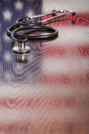 Stethoscope with American Flag Reflection on Wooden Table.の写真素材