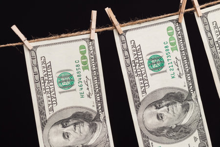 Hundred Dollar Bills Hanging From a Clothesline on a Dark Background.