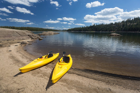 Pair of Yellow Kayaks on a Beautiful Mountain Lake Shore.の写真素材