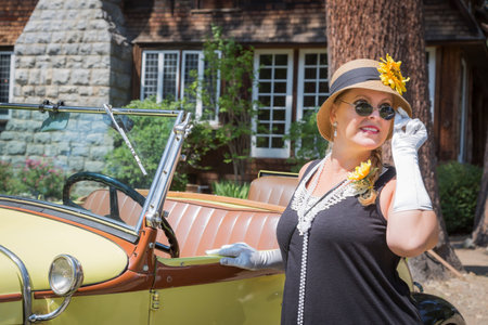 Attractive Young Woman in Twenties Outfit Near Antique Automobile.