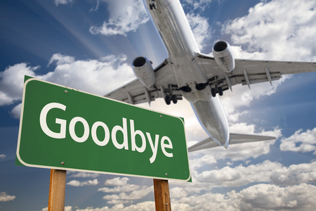 Goodbye Green Road Sign and Airplane Above with Dramatic Blue Sky and Clouds. Goodbye Green Road Sign and Airplane Above with Dramatic Blue Sky and Clouds.
