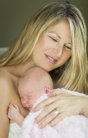 Young Caucasian Beautiful Mother Holding Her Precious Newborn Baby Girl.の写真素材