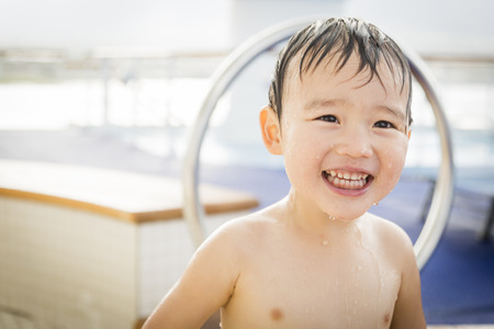 Mixed Race Boy Having Fun at the Water Park with Large Rubber Duck in the Background.の写真素材