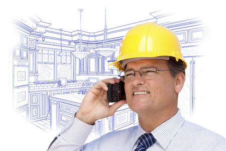 Contractor in Hardhat on Cell Phone Over Custom Kitchen Drawing on White.の写真素材