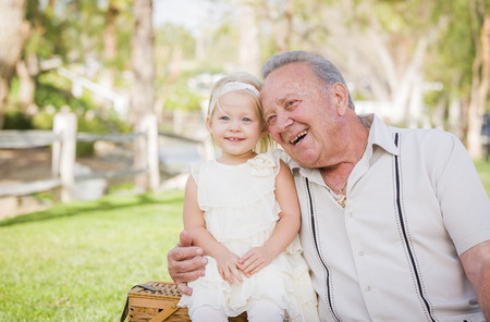 Loving Grandfather and Granddaughter Hugging Outside At The Park.の写真素材