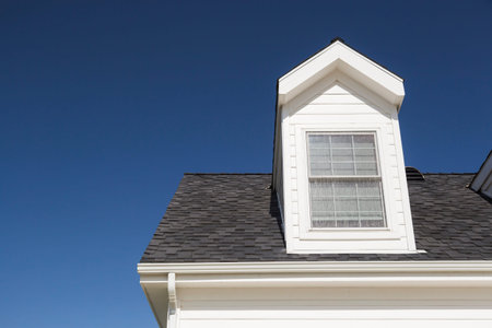 Roof of House and Windows Against Beautiful Deep Blue Sky.