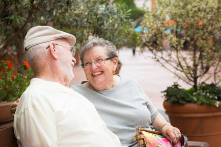 Happy Senior Couple Resting on a Bench in the Market Place.