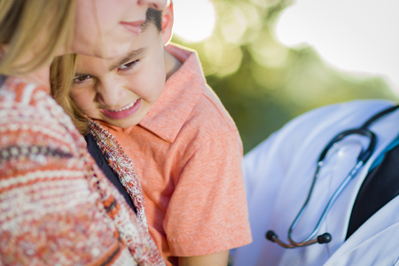 Sick Mixed Race Boy, His Mother and Hispanic Doctor Outdoors.の写真素材