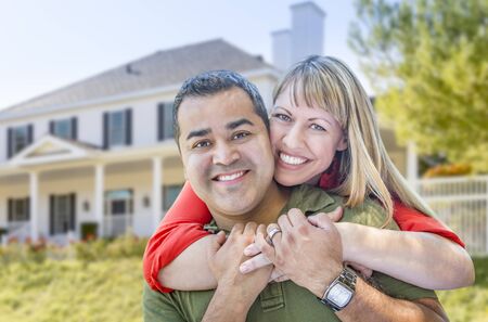 Happy Mixed Race Couple in Front of Beautiful House.の写真素材
