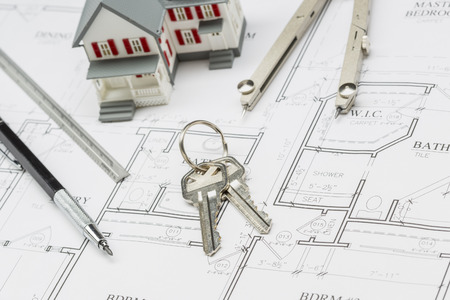 Model Home, Pencil, Ruler, Compass and Key Resting on Custom House Plans.の写真素材