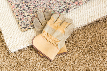 Construction Gloves On Pulled Back Carpet and Pad In Room.の写真素材