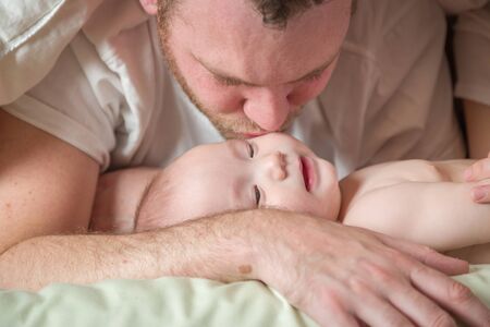 Mixed Race Chinese and Caucasian Baby Boy Laying In Bed with His Father and Mother.の写真素材