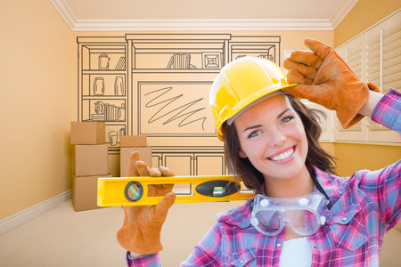 Female Construction Worker Holding Level In Front of Custom Built In Entertainment Unit Drawing in...