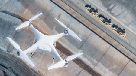 Unmanned Aircraft System (UAV) Quadcopter Drone In The Air Over Construction Site.