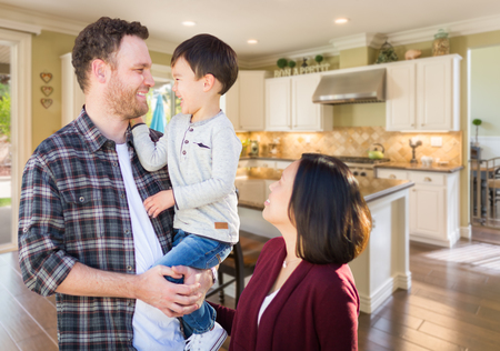 Young Mixed Race Caucasian and Chinese Family Inside Custom Kitchen.の写真素材