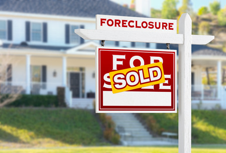 Left Facing Foreclosure Sold For Sale Real Estate Sign in Front of House.の写真素材