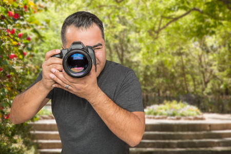 Hispanic Young Male Photographer With DSLR Camera Outdoorsの写真素材