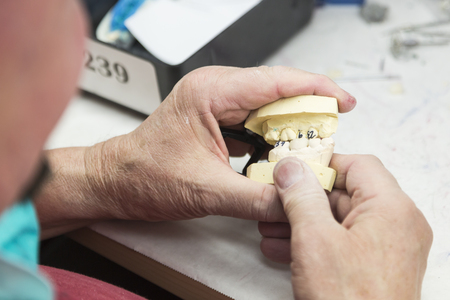 Male Dental Technician Working On A 3D Printed Mold For Tooth Implants In The Lab.の写真素材