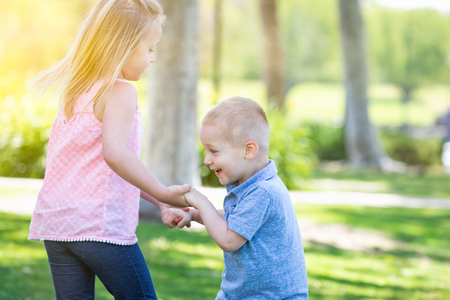 Young Brother and Sister Playing At The Park Togther.の写真素材