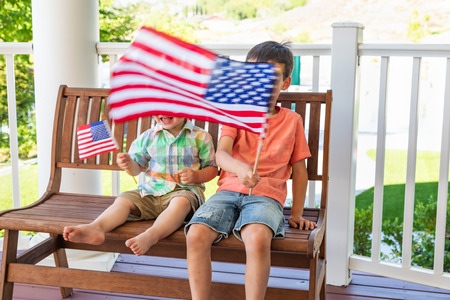 Young Mixed Race Chinese and Caucasian Brothers Playing With American Flagsの写真素材