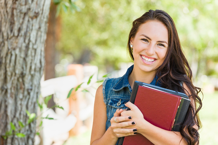 Attractive Smiling Mixed Race Young Girl Student with School Books Outdoorsの写真素材