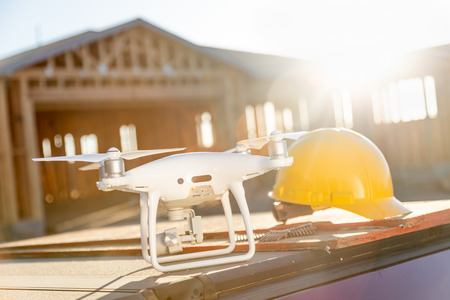 Drone Quadcopter Next to Hard Hat Helmet At Construction Site.の写真素材