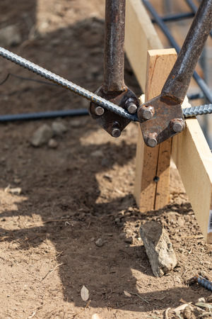 Worker Using Tools To Bend Steel Rebar At Construction Site.の写真素材