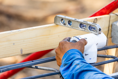 Plumber Using Level While Installing PVC Pipe At Construction Site.の写真素材